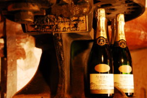 Our cava next to an old grape press showcasing the heritage of our masia